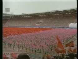 April 16, 1992 FILM MONTAGE WS Celebration in stadium for Kim Il-Sung's 80th birthday/ Sung kissing girl/ WS Dancers/ MS Portrait of Sung/ WS Gymnasts/ CU Yang Shangkun talking to woman/ MS Dancers/ ZO WS Dancers in stadium/ North Korea/ AUDIO Stock Footage