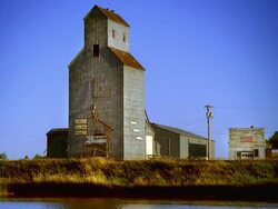 WS View of grain elevator and pond at evenin / South Dakota, United States Stock Footage