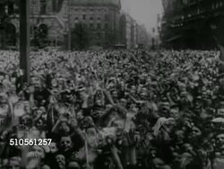 1936: HITLER ON BALCONY: VS HUGE Crowd of people in street, holding small swastika flags, waving, holding arms upward, Adolf Hitler raising hand to people, Hermann Goering, Goebbels standing w/ other Nazis BG. Goering pointing. Hitler gesturing. Instructional Video