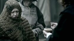 Nostradamus gives an ill villager medicine from a small jar and she eats it. Stock Footage