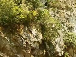 MS POV SLO MO Shot of brown cliff with some green vegetation / Muang Ngoi, Luang Prabang, Laos Stock Footage