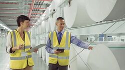 Businessman and businesswoman talking in paper mill Stock Footage