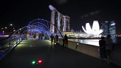 Guests and tourists use the Helix Bridge to access the integrated resort at Marina Bay Sands in Singapore. Stock Footage