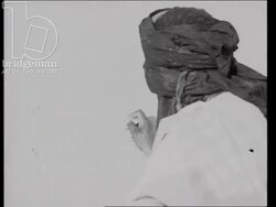 Timbuktu in 1930s, men build houses out of clay, mosque, man writes in the Tamasheq language on a wall, market place, Fort Bonnier Stock Footage