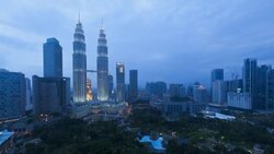 Facade lights illuminate the Petronas Twin Towers late in the day. Stock Footage