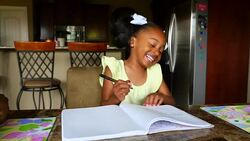 MS Smiling young girl in discussion with father while drawing in notebook at dining room table Stock Footage