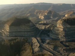 Wide Shot aerial tracking,left , A dirt road winds through a large strip mine. / West Virginia Stock Footage
