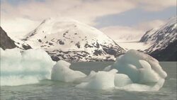Arctic ice floats along Alaska's snowy, mountainous coast. Stock Footage