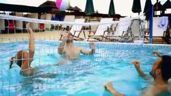 Friends playing volleyball in swimming pool. Stock Footage