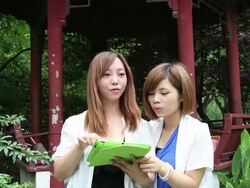 Young women using a digital tablet at the tourist spot in Yuyuan Stock Footage