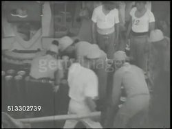 1942: JAPANESE NAVY: VS Small Japanese cargo ship docking w/ another ship (unconfirmed), Imperial Japanese Navy sailors loading, unloading, & stocking shells. World War II, WWII, Pacific Front, mobilizing Instructional Video