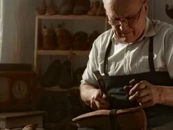 HD DOLLY: Shoemaker Fastening The Outsole Stock Footage