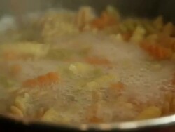 Mixing boiling multicolor pasta with a fork Stock Footage