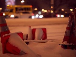 A few orange cones in the snow and traffic behind Stock Footage