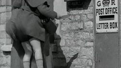 MS Mother holding up a child to drop a letter in the post office slot / United Kingdom Stock Footage