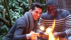 MS  Two young men playing with sparklers, smiling Stock Footage