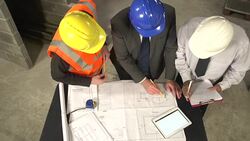 Construction workers looking at Blueprints / Plans from above Stock Footage