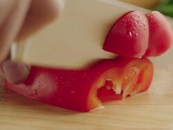 CU Shot of half organic red bell pepper on kitchen cutting baord, vegetable cut into multiple slices with steel knife / Los Angeles, California United States Stock Footage