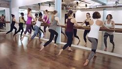 Young women doing exercise next to mirror Stock Footage