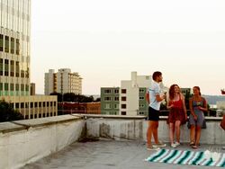 Friends having drinks on rooftop of building Stock Footage
