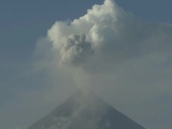 Zoom out of volcano erupting ash and steam over city, Philippines, Dec 2009 Stock Footage