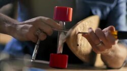 Craftsman fastens truck to custom wooden longboard deck in skate shop Stock Footage