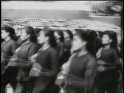 B/W 1950s close up PAN women in uniforms marching past camera in parade / North Vietnam / newsreel Stock Footage