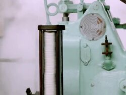 CU TD vintage can closing machine fully operational in olive processing plant with stack of can lids and freshly sealed cans rolling out of chute / Ontario, California, USA  Stock Footage