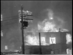 B/W 1934 buildings + telephone pole on fire in Chicago stockyard / newsreel Stock Footage