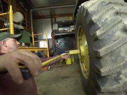 MS PAN Worker measuring tire on farm planter / Chelsea Michigan Stock Footage