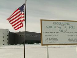 MS of Plaque at Geographic South Pole, US flag and Scott Amundsen Station / South Pole, Antarctica Stock Footage