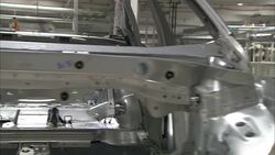 An auto body shell moves along a conveyor in a factory. Stock Footage