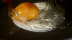 SLO MO LD cracking an egg into the skillet Stock Footage