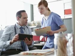 Doctor and nurse reviewing medical charts in office Stock Footage