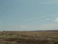 Driving by sand hills under a blue sky with clouds Stock Footage