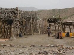 Wooden huts and child carrying load Stock Footage