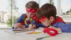 Superhero children drawing at table Stock Footage
