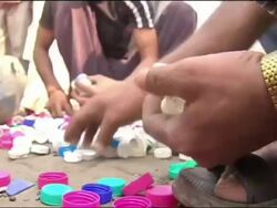 Recycling of plastic bottle tops in the street in Mumbai Stock Footage
