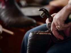 CU PAN R/F boot maker stretching and tacking vamp to sole of cowboy boot Stock Footage