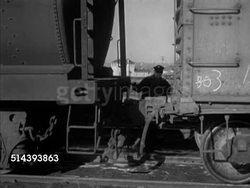 1953: UNION PACIFIC TRAIN YARD:  VS Locomotive engine 9031 backing up to freight car, coupling, Art Franks talking w/ conductor Garret 'Gabe' Conant, checking watches, Frank climbing into engine. Instructional Video