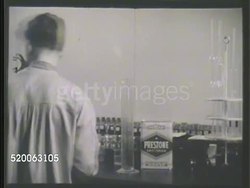 1935: RESEARCH LABORATORY: VS Carbon chemist pouring Prestone Anti-Freeze solution into beaker w/ 50% water. VS Pouring mix into larger beaker, turning on heat, chemist measuring water loss of pipe. MCU Valve dripping liquid. Instructional Video