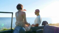 MS Smiling couple sitting in discussion outside of convertible off road vehicle parked along waterfront on summer evening Stock Footage