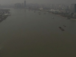 Wide angle aerial view of multiple barges sailing along river through Shanghai, China Stock Footage