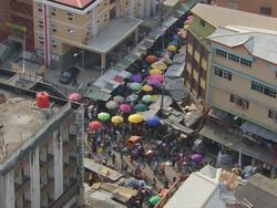 MS Shot of People walking in market and Colouredred umbrellas / Lagos, Nigeria Stock Footage
