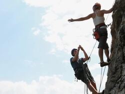 Climbers take picture while hanging from rock wall Stock Footage
