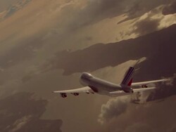 AERIAL tracking shot 747 jet flying over water + land through clouds / orange light reflected in water Stock Footage