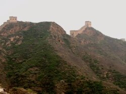 A view from atop the Great Wall of China, with the wall and it's corresponding watch towers climbing up the steep mountains, panning from left to right. Stock Footage