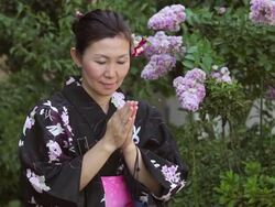 CU Shot of Mature woman in traditional Japanese clothing calling prays / Tokyo, Japan Stock Footage