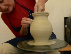 MS TU Shot of female potter shapes pitcher from lump of clay on potterwheel at pottery / Landshut, Bavaria, Germany Stock Footage
