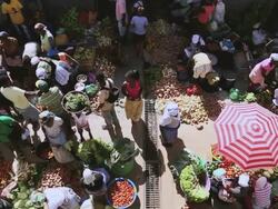 WS HA SLO MO Shot over African market street vendors selling fresh vegetables and fruits / Santiago, Cape Verde Stock Footage